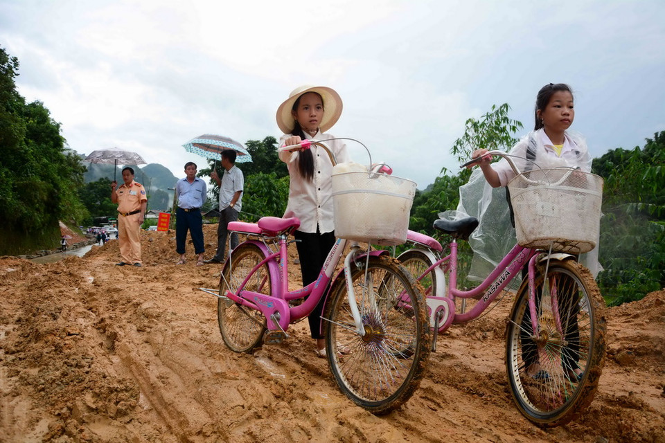  Nhiều học sinh không kịp đến trường đúng giờ khai giảng do điểm sạt lở. (Ảnh: Xuân Tư/TTXVN)