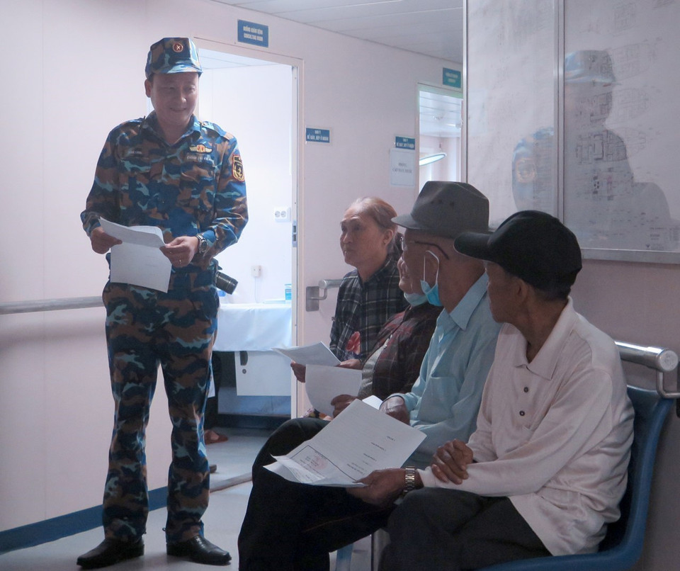 Bác sỹ trên tàu bệnh viện Khánh Hòa 01 làm thủ tục để bệnh nhân vào khám bệnh. (Ảnh: Xuân Triệu/TTXVN)