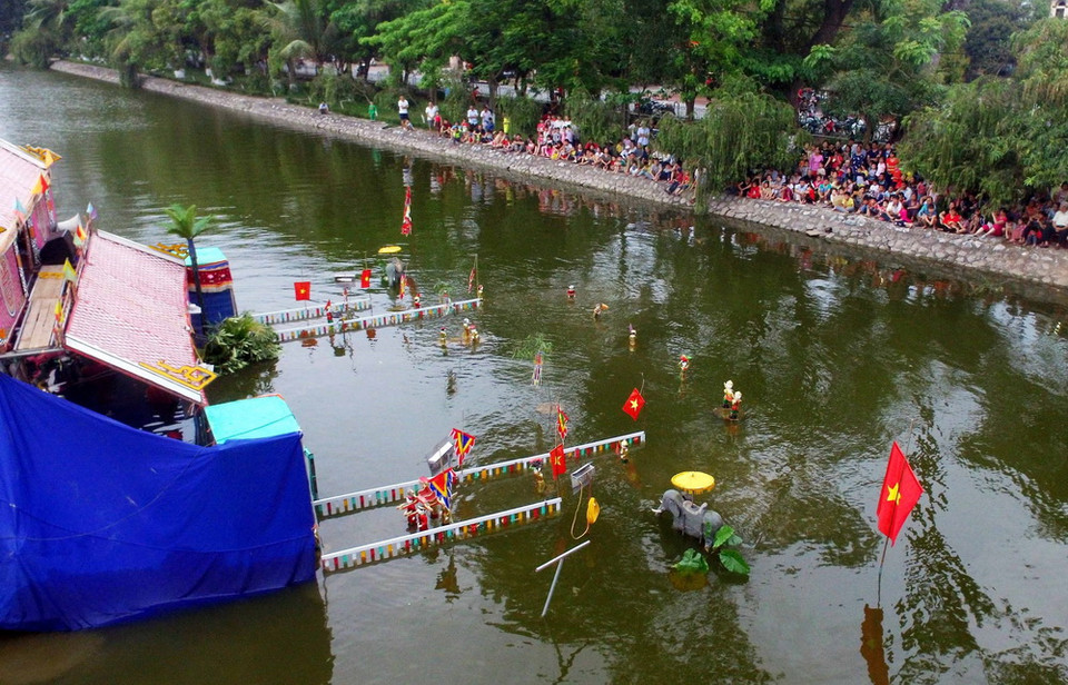 Chương trình múa rối nước tại lễ hội thu hút du khách tới xem. (Ảnh: Phạm Kiên/TTXVN)