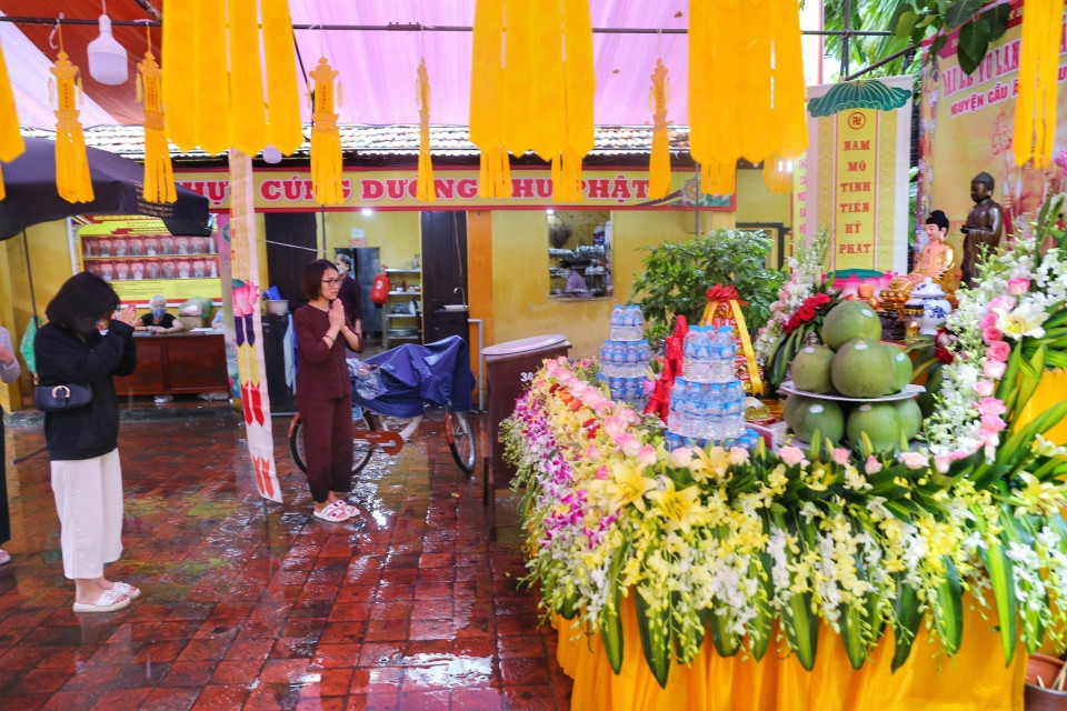 Người dân thành tâm cầu khấn tại chùa Phúc Khánh cho dù trời mưa to. (Ảnh: Tuấn Đức/TTXVN)