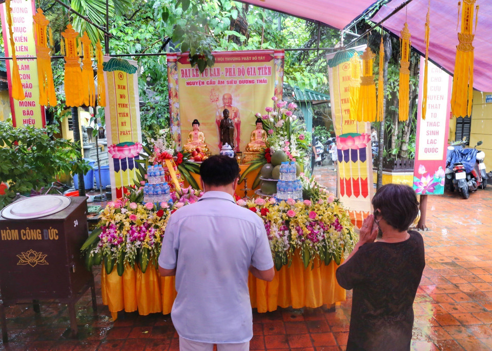 Người dân thành tâm cầu khấn tại chùa Phúc Khánh cho dù trời mưa to. (Ảnh: Tuấn Đức/TTXVN)