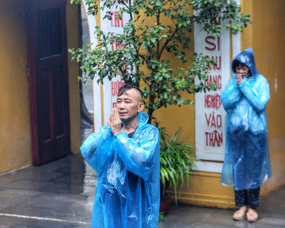 Người dân thành tâm cầu khấn tại chùa Quán Sứ dù trời mưa to. (Ảnh: Tuấn Đức/TTXVN)