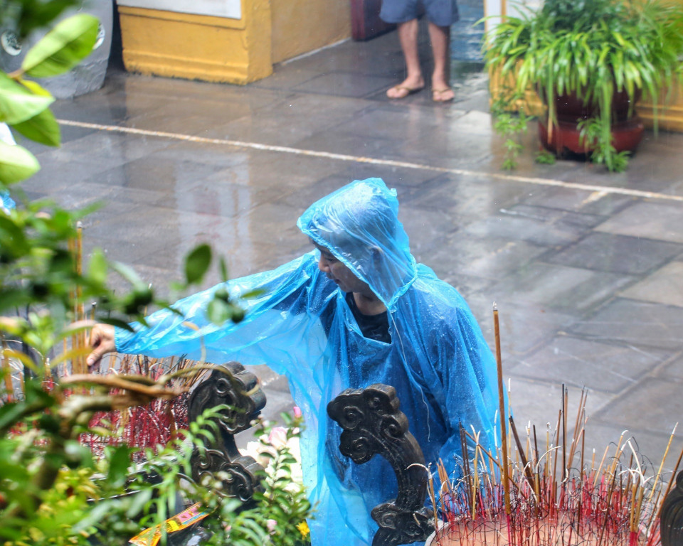 Người dân thành tâm cầu khấn tại chùa Quán Sứ dù trời mưa to. (Ảnh: Tuấn Đức/TTXVN)