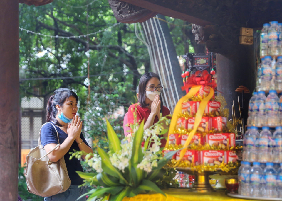 Người dân thành tâm cầu khấn tại chùa Phúc Khánh cho dù trời mưa to. (Ảnh: Tuấn Đức/TTXVN)