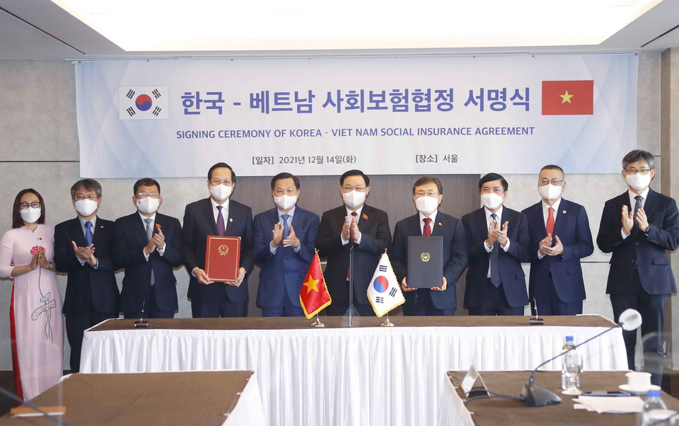 Chủ tịch Quốc hội Vương Đình Huệ chứng kiến Bộ trưởng Bộ Lao động-Thương binh và Xã hội Việt Nam Đào Ngọc Dung và Bộ trưởng Bộ Y tế và Phúc lợi Hàn Quốc Kwon Deok-cheol thực hiện Lễ ký. (Ảnh: Doãn Tấn/TTXVN)