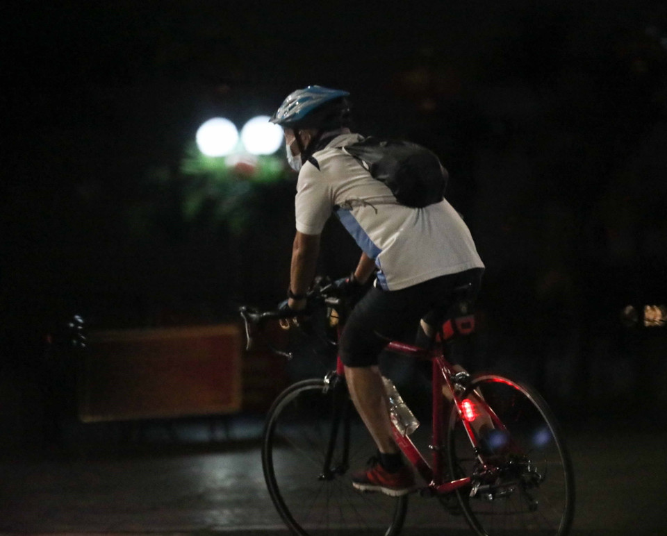 Người dân đạp xe trên đường Thanh Niên từ sớm để tránh lực lượng chức năng (ảnh chụp lúc 4h31 phút). (Ảnh: Thanh Tùng/TTXVN)