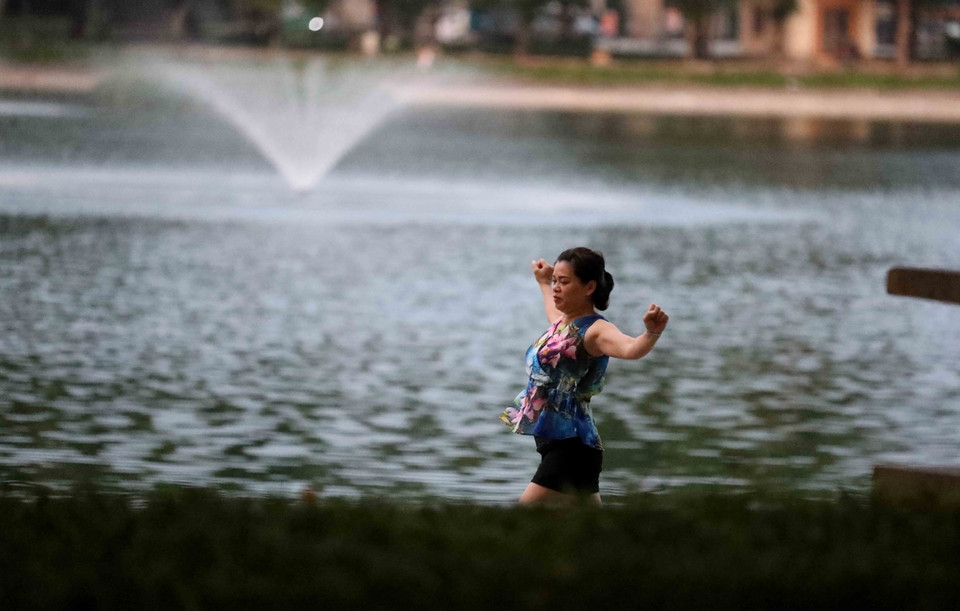 Vượt qua rào chặn để vào tập thể dục tại hồ Thiền Quang lúc 5h sáng 26/7. (Ảnh: Nhật Anh/TTXVN)