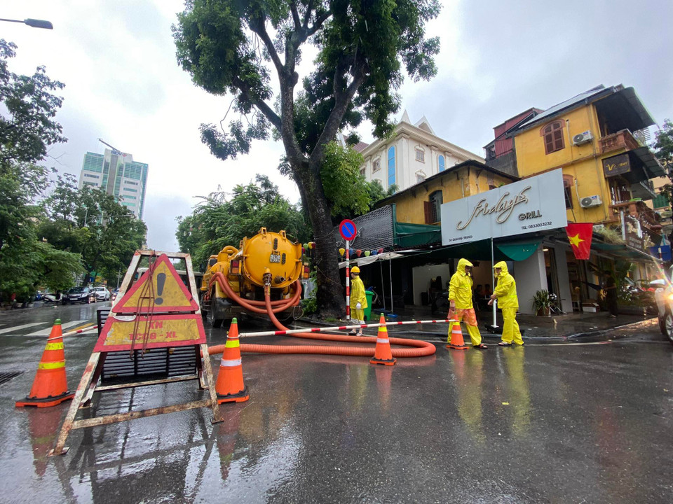 Lực lượng chức năng đã có mặt tại các điểm thoát nước tại nút giao cắt Trần Quốc Toản-Quang Trung. (Ảnh: PV/Vietnam+) 