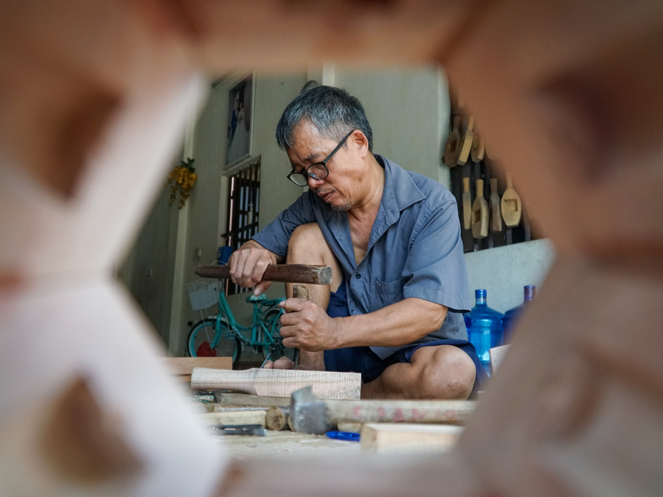 Khi có nhiều đơn hàng, con cháu cũng giúp đỡ ông nhiều khâu, chỉ duy nhất khâu điêu khắc thủ công là ông phải đích thân làm để còn ổn định chất lượng, giữ uy tín với khách hàng. (Ảnh: Minh Hiếu/Vietnam+)