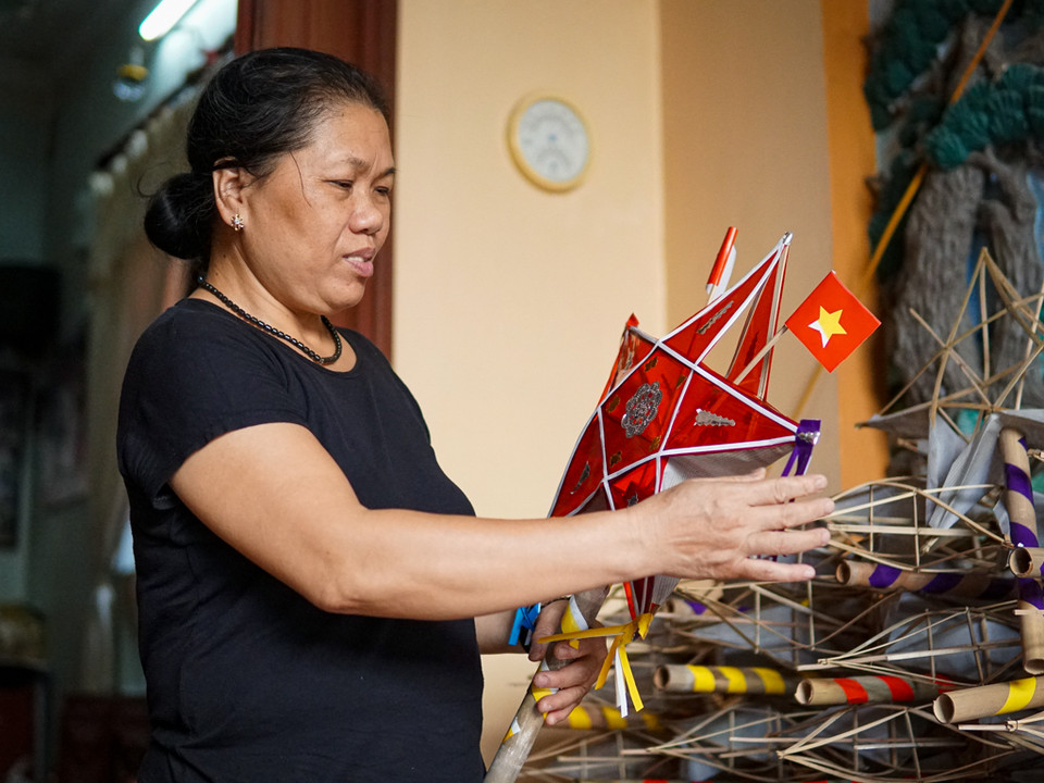 Cách trung tâm Thủ đô khoảng 15km, đến làng Hậu Ái (xã Vân Canh, huyện Hoài Đức, Hà Nội) vào mỗi dịp tết Trung Thu, ai cũng nhắc đến bà Nguyễn Thị Tuyến – người "thắp sáng" cho những chiếc đèn ông sao truyền thống. Trải qua bao thăng trầm, gia đình bà Tuyến là một trong những hộ hiếm hoi còn gìn giữ nghề làm đèn ông sao ở Thủ đô. (Ảnh: PV/Vietnam+)