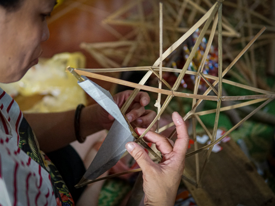 'Từ việc làm khung, cắt giấy, dán trang trí, tất cả các công đoạn đều được làm thủ công. Trong đó việc định hình khung là công đoạn công phu nhất,' bà Tuyến cho hay. (Ảnh: PV/Vietnam+)