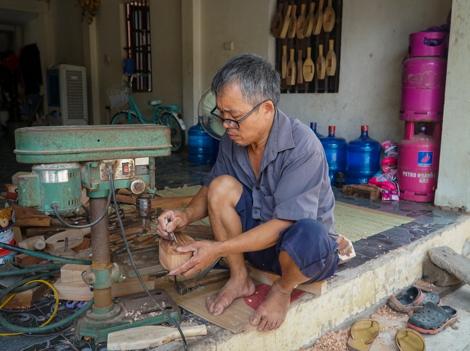 Người nghệ nhân có 40 năm làm nghề đục khuôn bánh cho biết khách hàng thiết kế bản vẽ rồi gửi hình ảnh cho ông qua điện thoại để đục khuôn. (Ảnh: Minh Hiếu/Vietnam+)