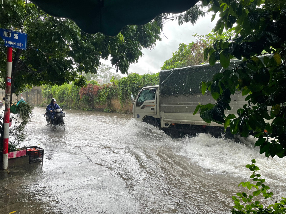 Phương tiện lưu thông qua phố Thịnh Liệt (Hoàng Mai, Hà Nội) gặp khó khăn do mưa lớn. (Ảnh: Anh Tú/Vietnam+) 