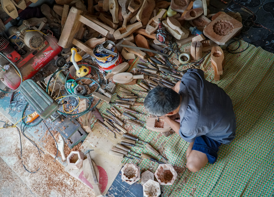 Đã gần 60 tuổi nhưng hơn 40 năm qua, ông Bản vẫn vững tay đẽo đục, gìn giữ và bảo tồn nghề làm khuôn bánh Trung Thu. (Ảnh: Minh Hiếu/Vietnam+)