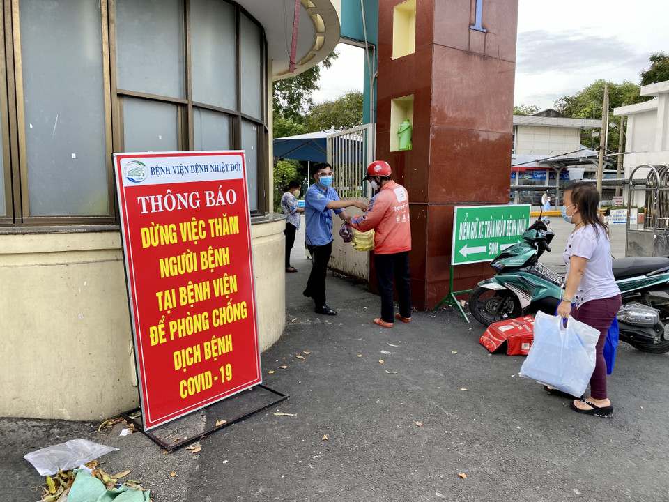 Mọi hoạt động 'tiếp tế' vật dụng, thức ăn cho bệnh nhân đều được lực lượng chức năng bệnh viện tiếp nhận, đảm bảo phòng chống dịch. (Ảnh: Hồng Giang/TTXVN)