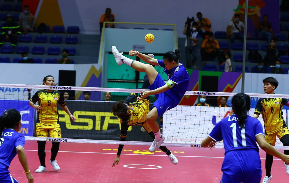 Pha cản phá cầu của đội tuyển Lào (áo xanh) trong trận gặp đội tuyển Malaysia (áo vàng). (Ảnh: An Thành Đạt/TTXVN)