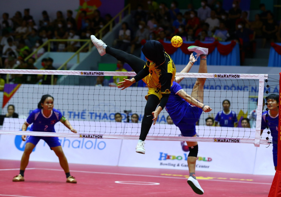 Pha cản phá cầu của đội tuyển nữ Malaysia (áo màu vàng) trong trận gặp đội tuyển Lào (áo màu xanh) . (Ảnh: An Thành Đạt/TTXVN)
