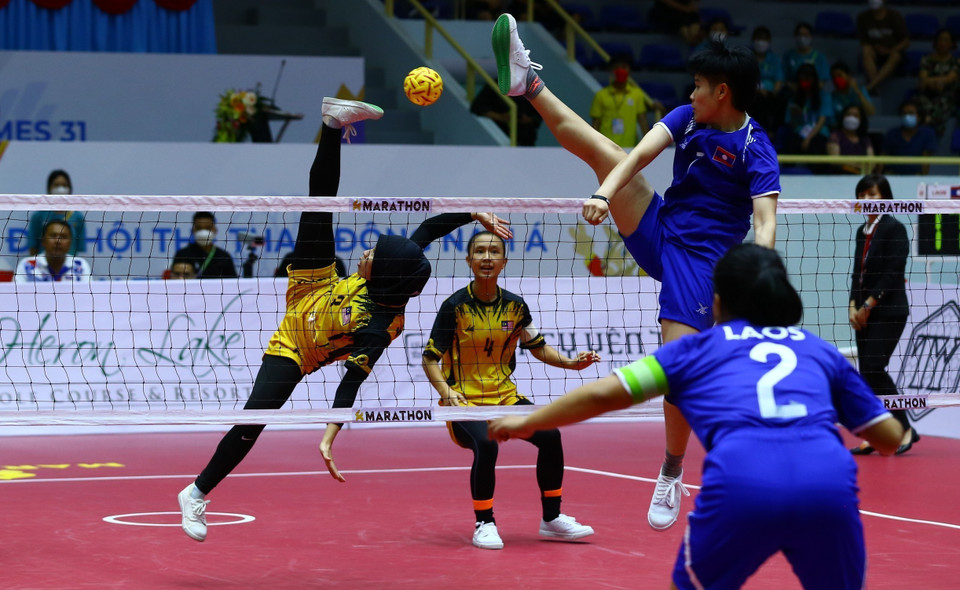 Pha cản phá cầu của đội tuyển Lào (áo xanh) trong trận gặp đội tuyển Malaysia (áo vàng). (Ảnh: An Thành Đạt/TTXVN)