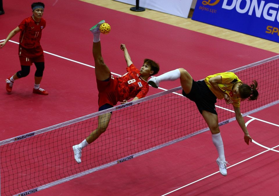 Pha lên lưới của cầu thủ đội tuyển Việt Nam (áo màu vàng) trong trận gặp Thái Lan. (Ảnh: An Thành Đạt/TTXVN)