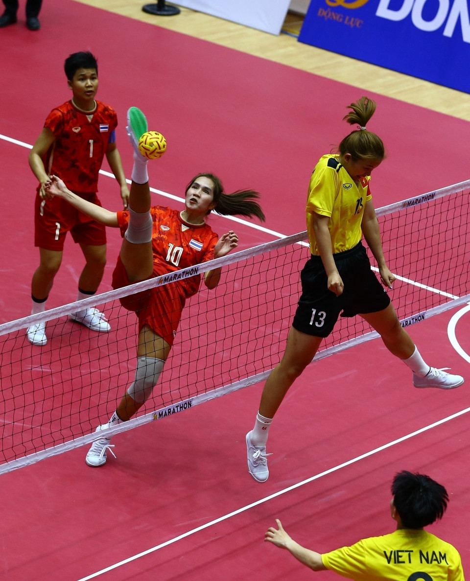 Pha lên lưới của đội tuyển nữ Thái Lan (áo màu đỏ) trong trận gặp đội chủ nhà. (Ảnh: An Thành Đạt/TTXVN)