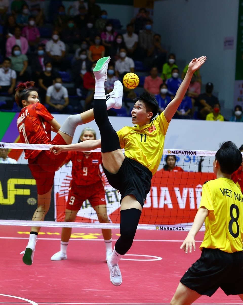 Pha lên lưới của đội tuyển Thái Lan (áo màu đỏ) và cản phá của cầu thủ đội tuyển Việt Nam (áo màu vàng). (Ảnh: An Thành Đạt/TTXVN)