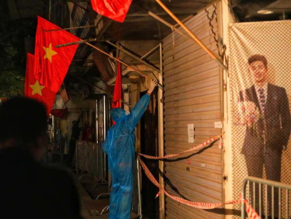 Lực lượng tình nguyện viên cắm cờ tổ quốc trước các nhà trên đường Nguyễn Trãi sau khi có quyết định dỡ bỏ phong tỏa ngõ 328, 330 đường Nguyễn Trãi. (Ảnh: Tuấn Anh/TTXVN)