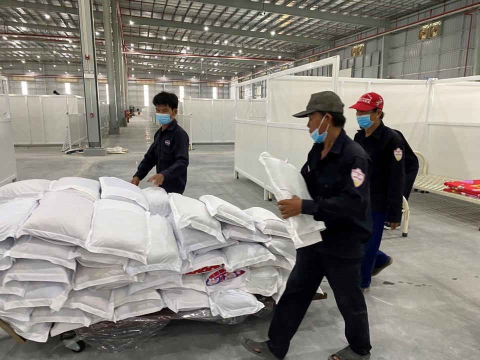 Đội thi công đang gấp rút trang bị gối nệm cho giường đặt tại bệnh viện dã chiến 5.000 giường để kịp thời đón nhận bệnh nhân. (Ảnh: Chí Tưởng/TTXVN)