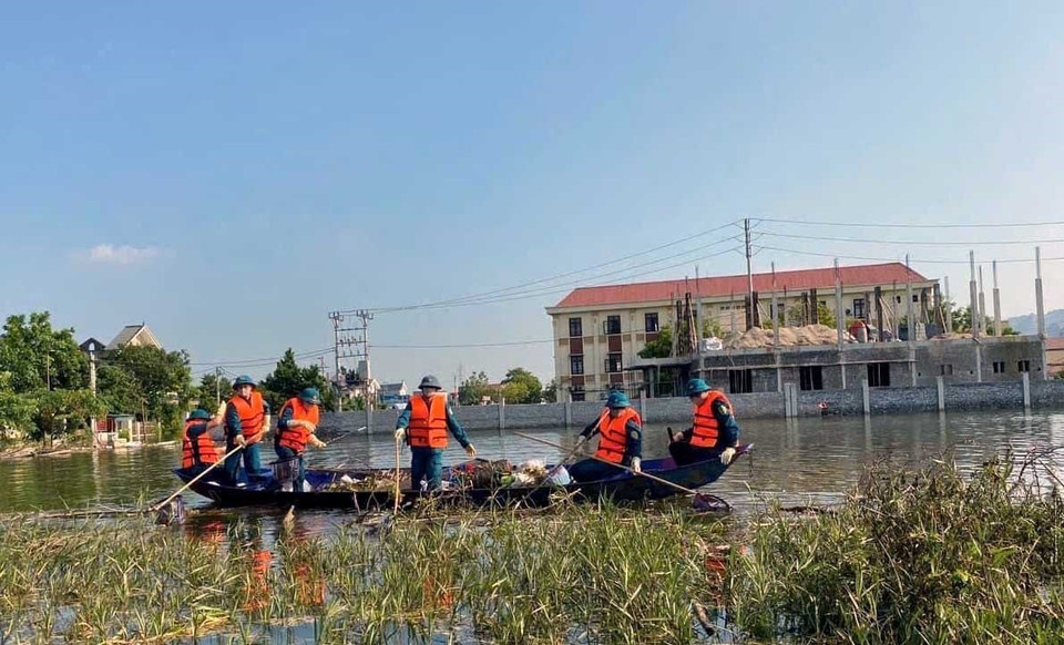 Cán bộ chiến sỹ, Lực lượng vũ trang Bộ Chỉ huy Quân sự tỉnh Hà Nam và dân quân tự vệ cùng người dân tham gia thu gom rác thải tại điểm ngập lụt Thị trấn Kiện Khê huyện Thanh Liêm. (Ảnh: Đại Nghĩa/TTXVN)