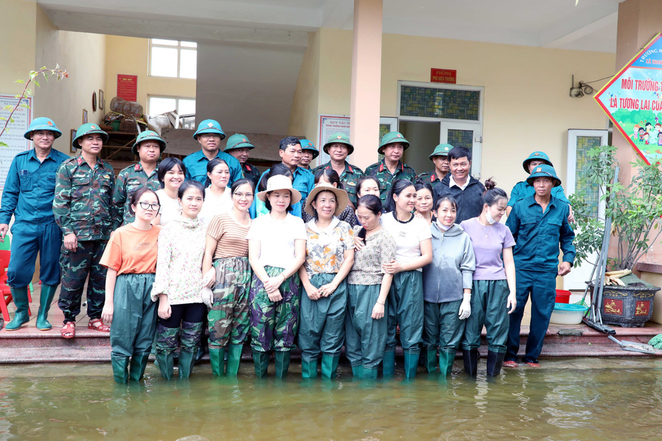 Cán bộ chiến sỹ, Lực lượng vũ trang Bộ Chỉ huy Quân sự tỉnh Hà Nam và các giáo viên Mầm non xã Thanh Nghị tham gia thu dọn vệ sinh tại điểm ngập lụt xã Thanh Nghị, huyện Thanh Liêm. (Ảnh: Đại Nghĩa/TTXVN)
