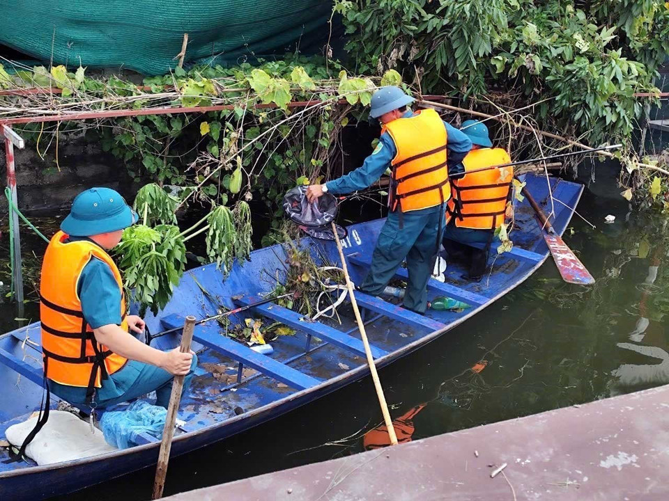 Cán bộ chiến sỹ, Lực lượng vũ trang Bộ Chỉ huy Quân sự tỉnh Hà Nam và dân quân tự vệ cùng người dân tham gia thu gom rác thải tại điểm ngập lụt Thị trấn Kiện Khê huyện Thanh Liêm (Ảnh: Đại Nghĩa/TTXVN)