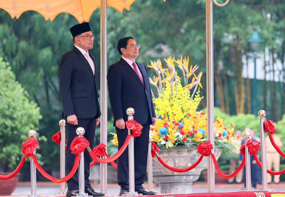 Thủ tướng Phạm Minh Chính và Thủ tướng Malaysia Anwar Ibrahim nghe quân nhạc cử quốc thiều hai nước. (Ảnh: Dương Giang/TTXVN)