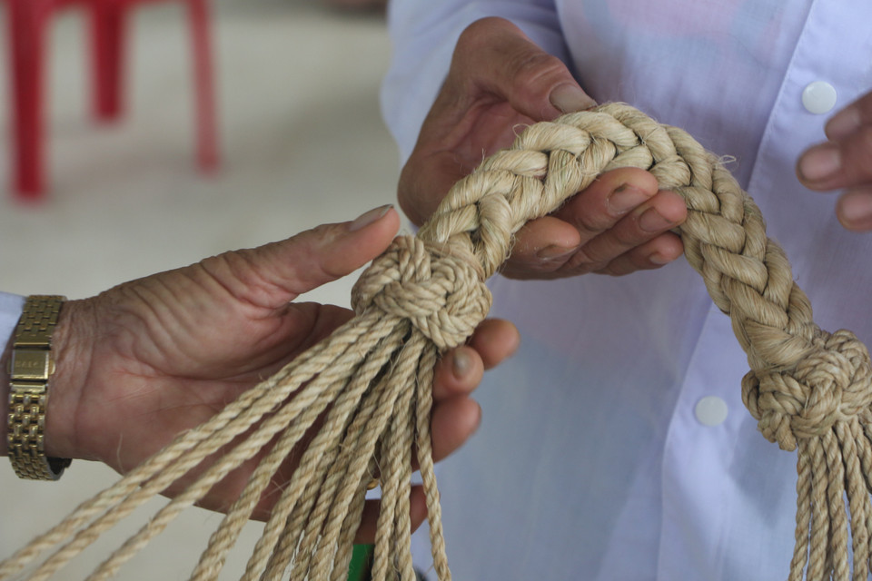 Công đoạn khó nhất trong việc đan võng là kết đai đầu võng. (Ảnh: Bích Huệ/TTXVN)