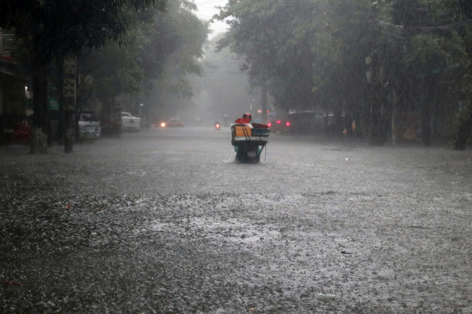 Nhiều tuyến đường nước không thoát kịp ngập sâu khiến các phương tiện giao thông di chuyển khó khăn. (Ảnh: Văn Tý/TTXVN)
