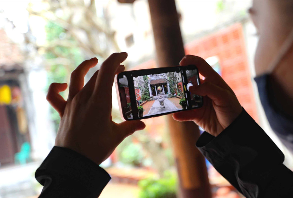 Du khách quốc tế lưu lại những hình ảnh đẹp khi ghé thăm đình Kim Ngân. (Ảnh: Thanh Tùng/TTXVN)