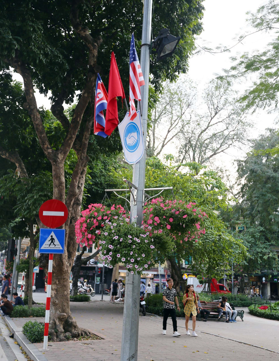 Cờ Mỹ, cờ Triều Tiên và cờ Việt Nam, bên dưới là biểu tượng hai bàn tay bắt chặt vào nhau thể hiện tinh thần của cuộc gặp lớn, được treo quanh hồ Hoàn Kiếm. (Ảnh: Danh Lam/TTXVN)