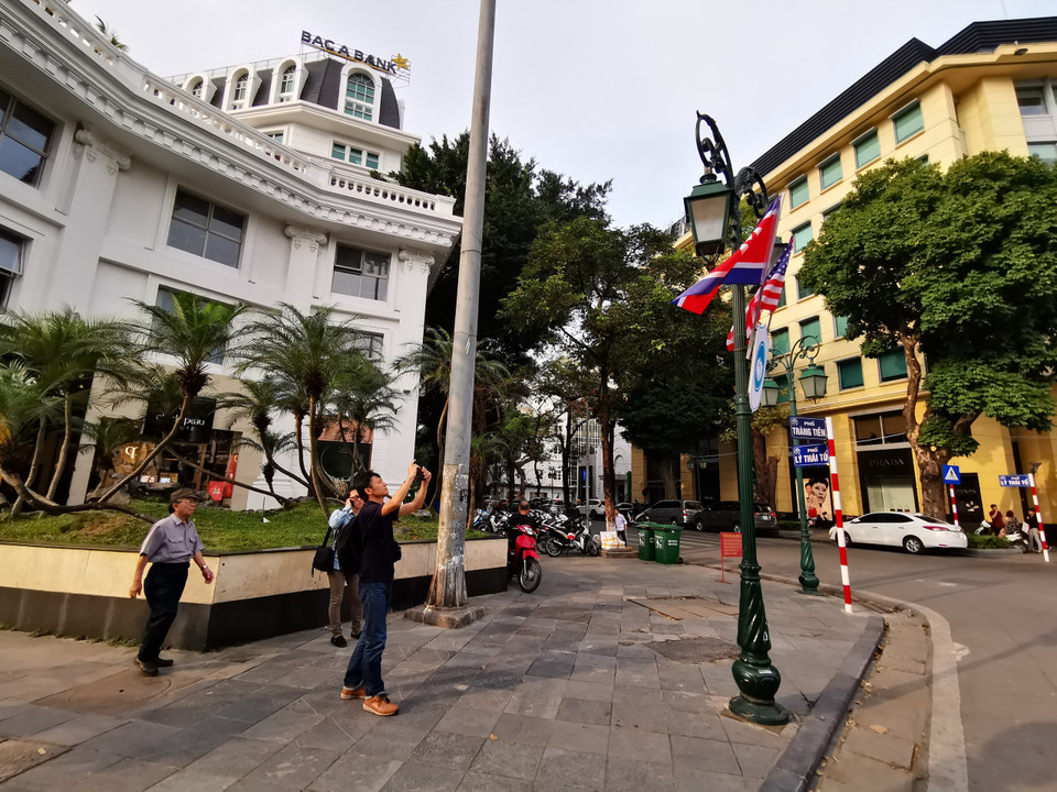 Cờ Mỹ và cờ Triều Tiên, bên dưới là biểu tượng hai bàn tay bắt chặt vào nhau thể hiện tinh thần của cuộc gặp lớn, được treo tại khu vực Quảng trường 19/8 - Nhà hát Lớn, quận Hoàn Kiếm. (Ảnh: Thành Đạt/TTXVN)