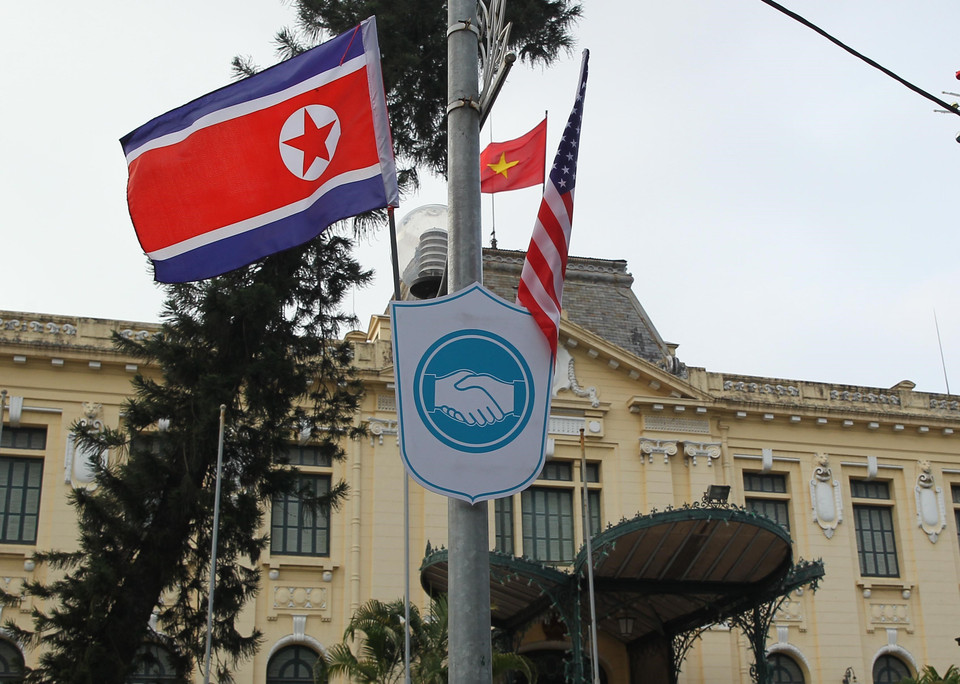 Cờ Mỹ và cờ Triều Tiên, bên dưới là biểu tượng hai bàn tay bắt chặt vào nhau thể hiện tinh thần của cuộc gặp lớn, được treo bên ngoài Nhà khách Chính phủ trên phố Ngô Quyền, quận Hoàn Kiếm. (Ảnh: Lâm Khánh/TTXVN)