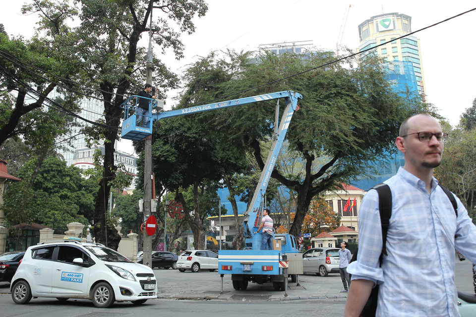 Nhân viên điện lực chỉnh trang tuyến đường dây trên phố Ngô Quyền, quận Hoàn Kiếm. (Ảnh: Lâm Khánh/TTXVN)