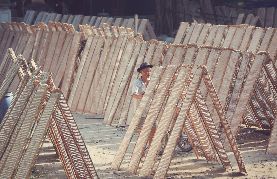 Dân làng Thổ Hà tranh thủ ánh nắng sáng sớm để phơi bánh đa nem. (Ảnh: Danh Lam/TTXVN)