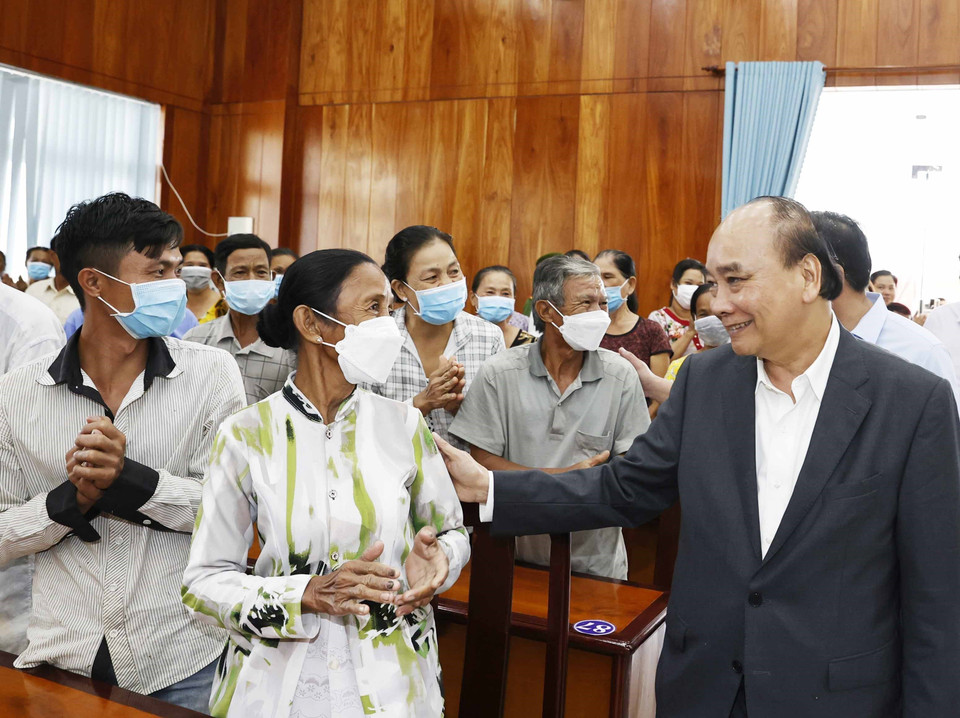 Chủ tịch nước Nguyễn Xuân Phúc hỏi thăm hộ nghèo, công nhân lao động có hoàn cảnh khó khăn, người nhiễm chất độc da cam tại huyện Châu Thành. (Ảnh: Thống Nhất/TTXVN)