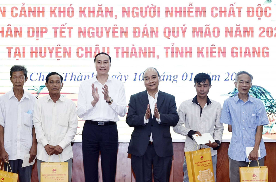 Chủ tịch nước Nguyễn Xuân Phúc tặng quà cho hộ nghèo, công nhân lao động có hoàn cảnh khó khăn, người nhiễm chất độc da cam trên địa bàn. (Ảnh: Thống Nhất/TTXVN)