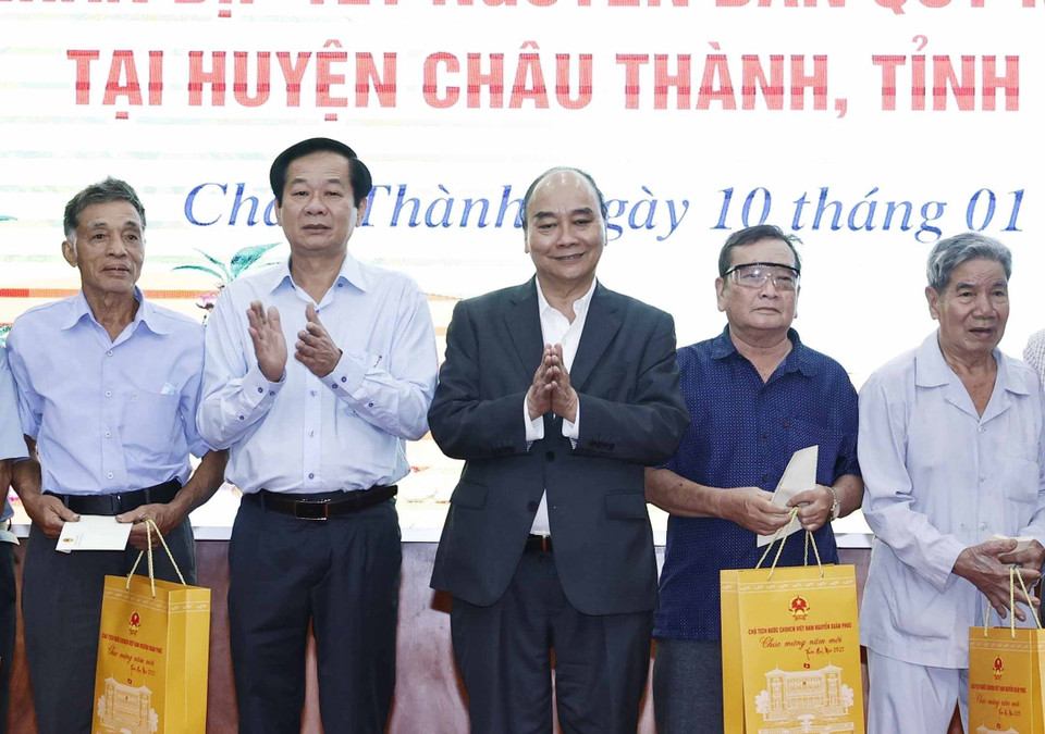 Chủ tịch nước Nguyễn Xuân Phúc tặng quà cho hộ nghèo, công nhân lao động có hoàn cảnh khó khăn, người nhiễm chất độc da cam trên địa bàn. (Ảnh: Thống Nhất/TTXVN)