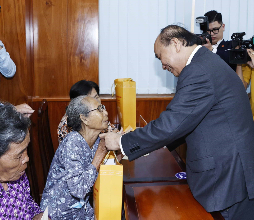 Chủ tịch nước Nguyễn Xuân Phúc tặng quà cho hộ nghèo, công nhân lao động có hoàn cảnh khó khăn, người nhiễm chất độc da cam trên địa bàn. (Ảnh: Thống Nhất/TTXVN)