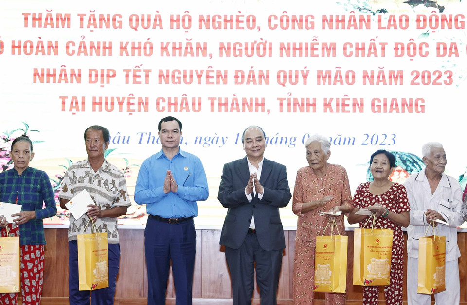 Chủ tịch nước Nguyễn Xuân Phúc tặng quà cho hộ nghèo, công nhân lao động có hoàn cảnh khó khăn, người nhiễm chất độc da cam trên địa bàn. (Ảnh: Thống Nhất/TTXVN)