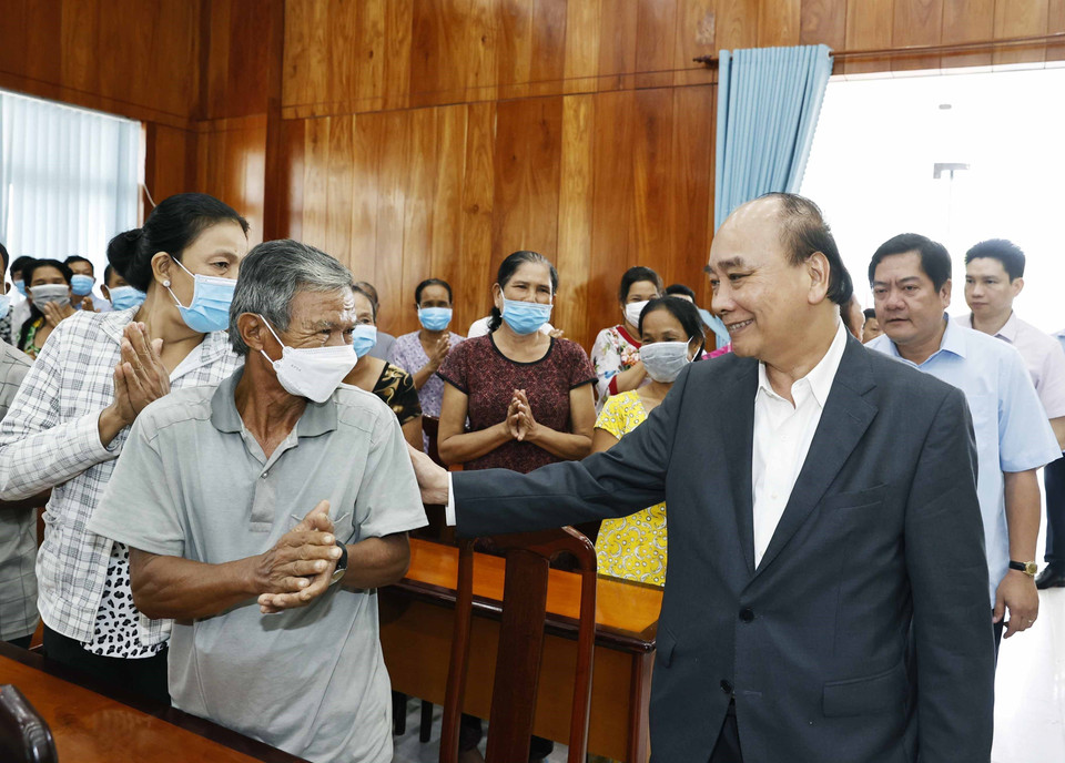 Chủ tịch nước Nguyễn Xuân Phúc hỏi thăm hộ nghèo, công nhân lao động có hoàn cảnh khó khăn, người nhiễm chất độc da cam tại huyện Châu Thành. (Ảnh: Thống Nhất/TTXVN)