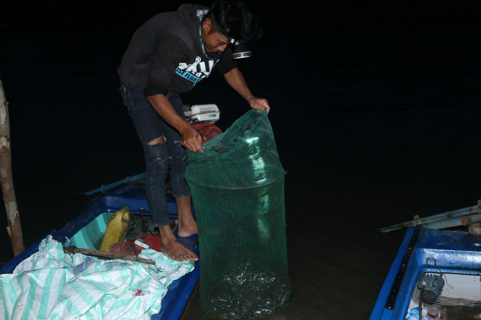 Người dân mang cá ra bán cho các thương lái ở chợ cá huyện Vĩnh Hưng. (Ảnh: Bùi Giang/TTXVN)