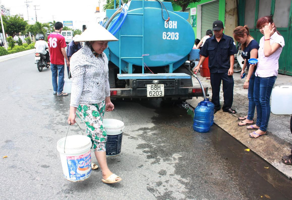 Người dân dùng tất cả các vật dụng có thể sử dụng được để lấy nước ở các xe bồn. (Nguồn: Bùi Trường Giang/Vietnam+)