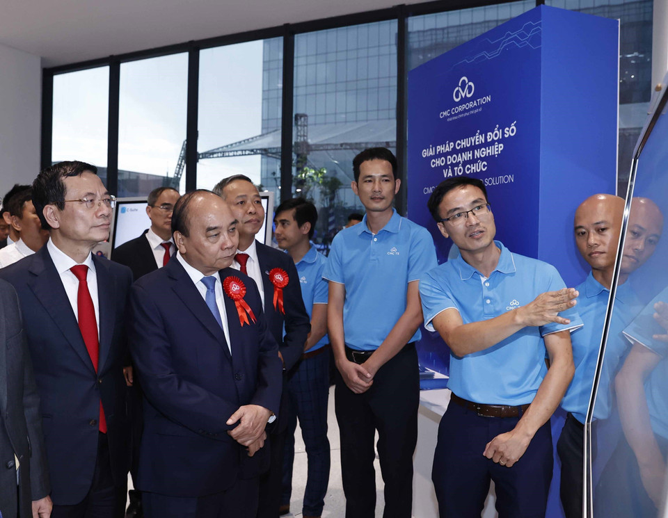 Chủ tịch nước Nguyễn Xuân Phúc và các đại biểu tham quan trưng bày, giới thiệu về các sản phẩm dữ liệu. (Ảnh: Thống Nhất/TTXVN)