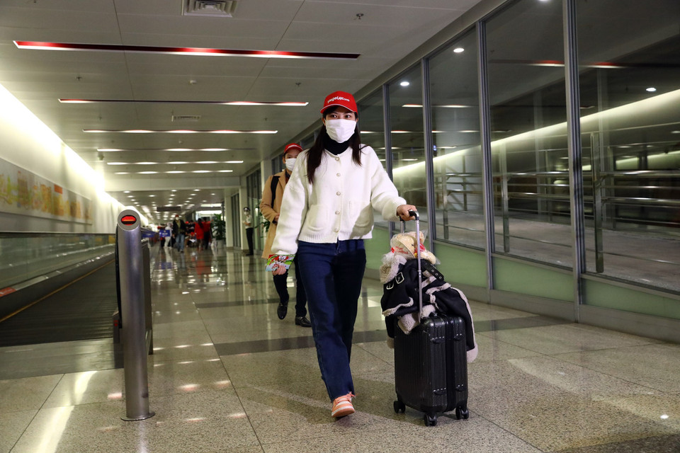 Hành khách trở về từ Nhật Bản tại sân bay quốc tế Nội Bài trên chuyến bay của hãng hàng không Vietjet. (Ảnh: Huy Hùng/TTXVN)