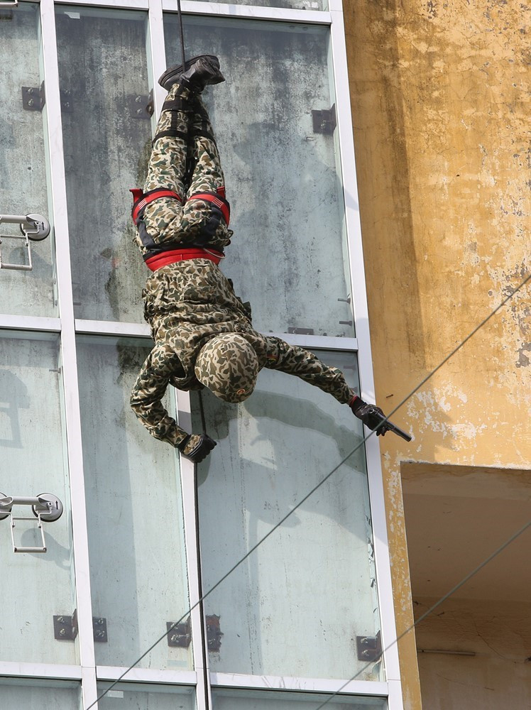 Bộ đội Đặc công trình diễn các kỹ thuật vừa tụt dây vừa tiêu diệt mục tiêu tại nhà cao tầng. (Ảnh: Dương Giang/TTXVN)